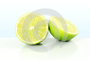 Fresh lemon lime citrus fruit cut in sky blue background