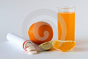 Fresh lemon and oranges, vitamin C pills in container isolated on white background.