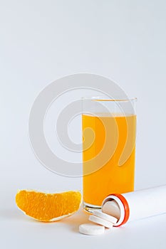 Fresh lemon and oranges, vitamin C pills in container isolated on white background.