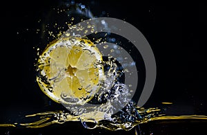 Fresh lemon splashing in water over black