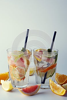 Fresh lemonade or cocktails. Refreshing summer homemade cocktail with lemon, lime, orange and grapefruit. two glasses or fruit