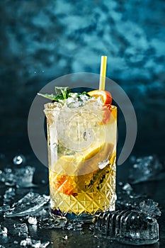 Fresh lemonade with mint, ginger, orange and ice in glass jar on the dark blue background. Summer cold drink and cocktail