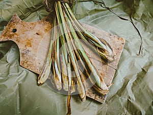 Fresh lemongrass stems on wooden cutting board