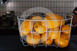 Fresh lemons. Basket of yellow lemons on cafe counter. Side view