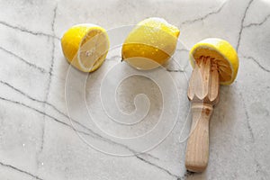 Fresh lemons and citrus reamer on marble photo