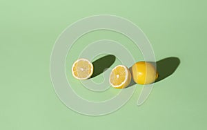Fresh lemons cut in half on a green background. Summer fruits