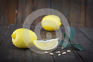 Fresh lemons with leaves on wooden background