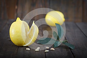 Fresh lemons with leaves on wooden background