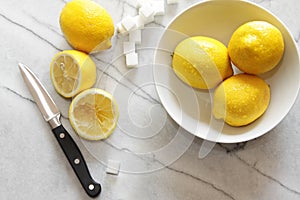 Fresh lemons and sugar cubes on marble counter