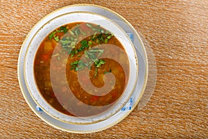 Fresh lentil soup in a white bowl, served in a restaurant setting, selective focus