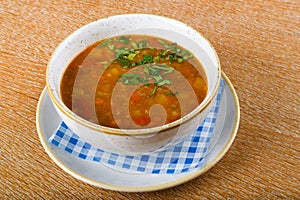 Fresh lentil soup in a white bowl, served in a restaurant setting, selective focus