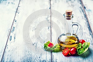 Fresh lettuce salad with cherry tomatoes radish and carafe with olive oil on wooden table.