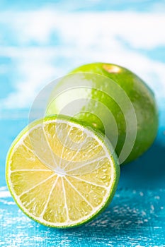 Fresh lime, half on wood background. Green citrus fruit