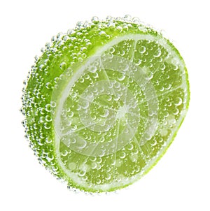 Fresh lime in sparkling water on white background