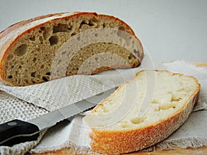 Fresh loaf of bread on handmade striped linen towel.