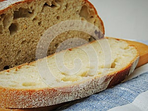 Fresh loaf of bread on handmade striped linen towel.