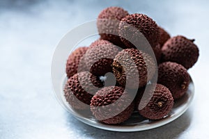 Fresh lychee fruits in a plate, close up, selective focus