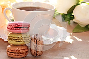 Fresh macaroons with tea on a light background.