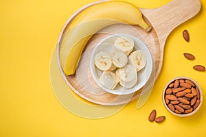 Fresh made banana smoothie in a glass on yellow background