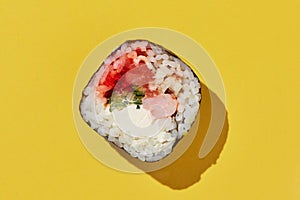 Fresh maki sushi roll on yellow background