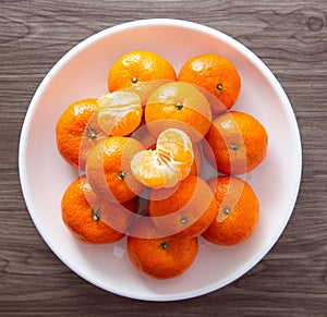 Fresh mandarin oranges fruit or tangerines on a wooden table