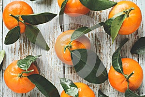 Fresh mandarins with leaves on wooden background