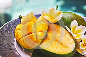 Fresh mango on a wooden tabel with tropical background. Soft focus.