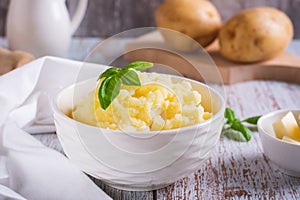 Fresh mashed potatoes and basil leaves in a bowl on the table