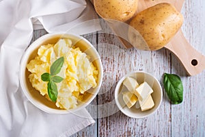 Fresh mashed potatoes and basil leaves in a bowl on the table top view