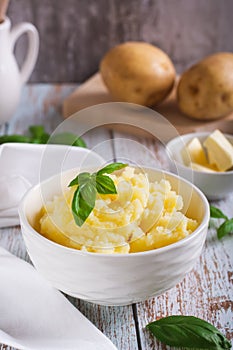 Fresh mashed potatoes and basil leaves in a bowl on the table vertical view