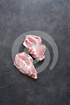 Fresh meat. Raw pork steak with spices on a black background. View from above