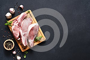 Fresh meat. Ribs and spices, basil on a blackboard on a dark background. Pork steak