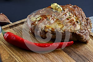 Fresh meat steak and seasonings on rustic wooden board over black background. Top view, flat lay, copy space banner.