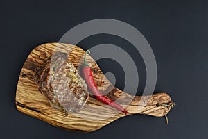 Fresh meat steak and seasonings on rustic wooden board over black background. Top view, flat lay, copy space banner.