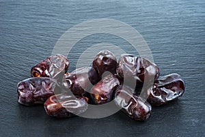 Fresh Medjool Dates on black background. Healthy organic product