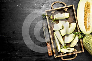 Fresh melon in a box with a hatchet.