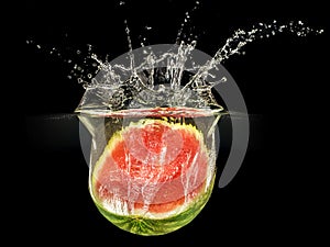 Fresh melon falling in water with splash on black background