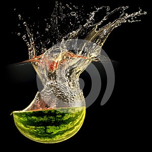 Fresh melon falling in water with splash on black