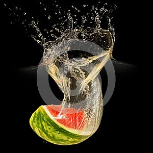 Fresh melon falling in water with splash on black