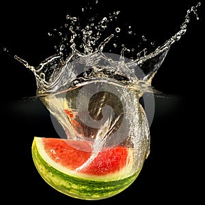 Fresh melon falling in water with splash on black