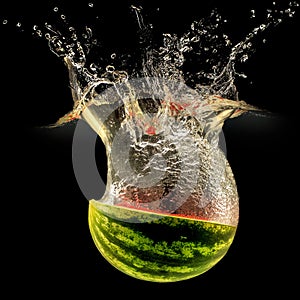 Fresh melon falling in water with splash on black background