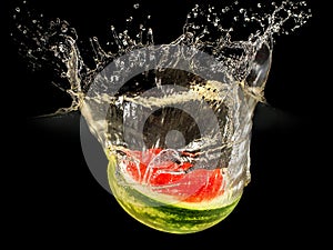 Fresh melon falling in water with splash on black background