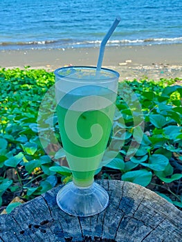 Fresh melon juice in hurricane glass with coastal background