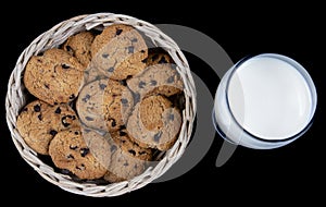Fresh Milk and Chocolate chip cookies in a bamboo basket isolated on black background