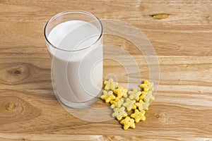 Fresh milk in glass with heart shape from star cereals on the w
