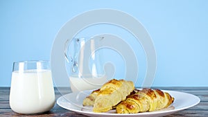 Fresh milk in glass and three delicious croissants for breakfast