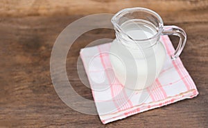 Fresh milk natural in a glass jug on wooden table - Serving breakfast milk concept