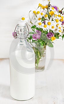 Fresh milk in old fashioned bottle and wildflowers