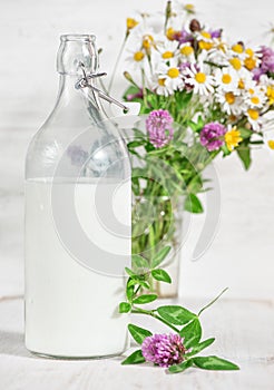 Fresh milk in old fashioned bottle and wildflowers