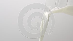 Fresh milk is pouring on a white background. Milk flow, dairy products